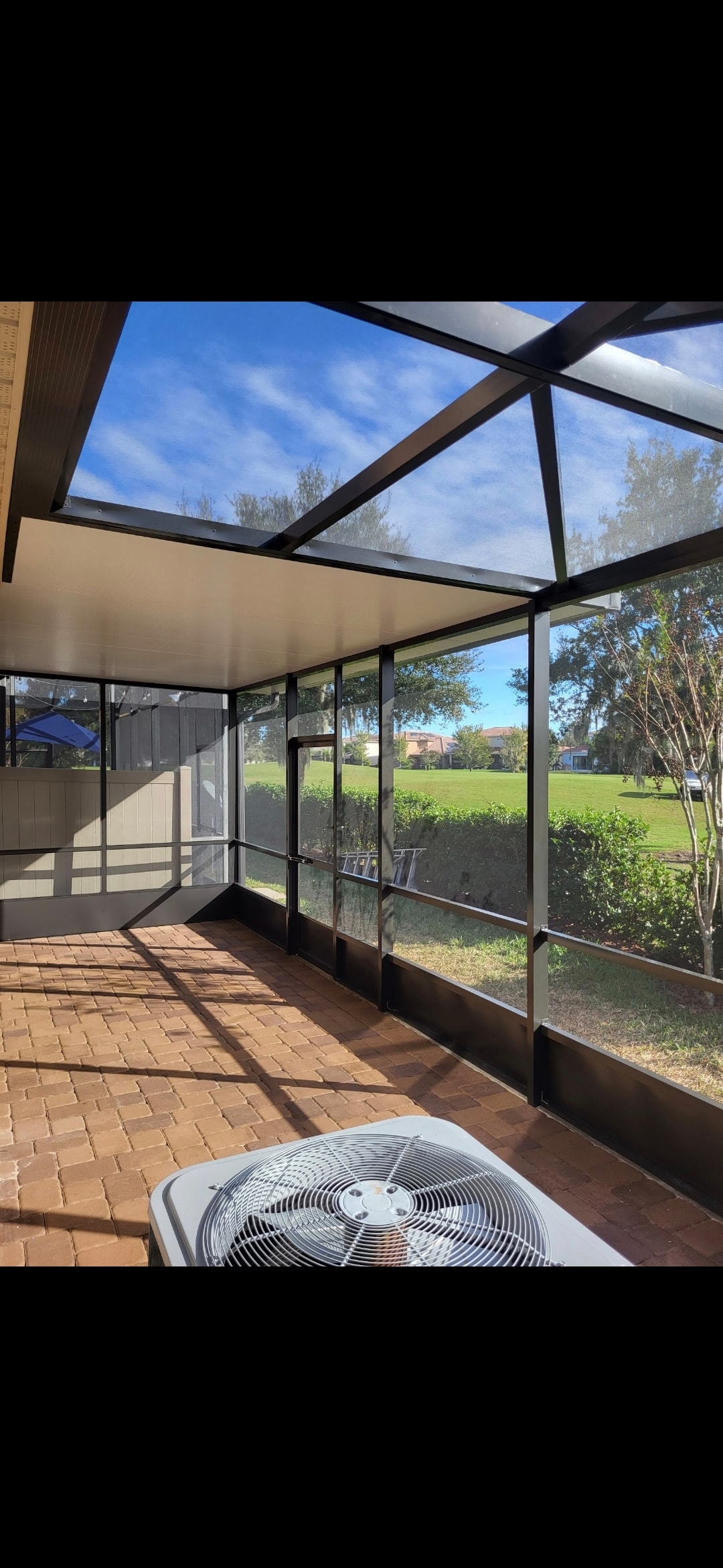 Interior view of glass panel screen room with skylight and brick patio floor