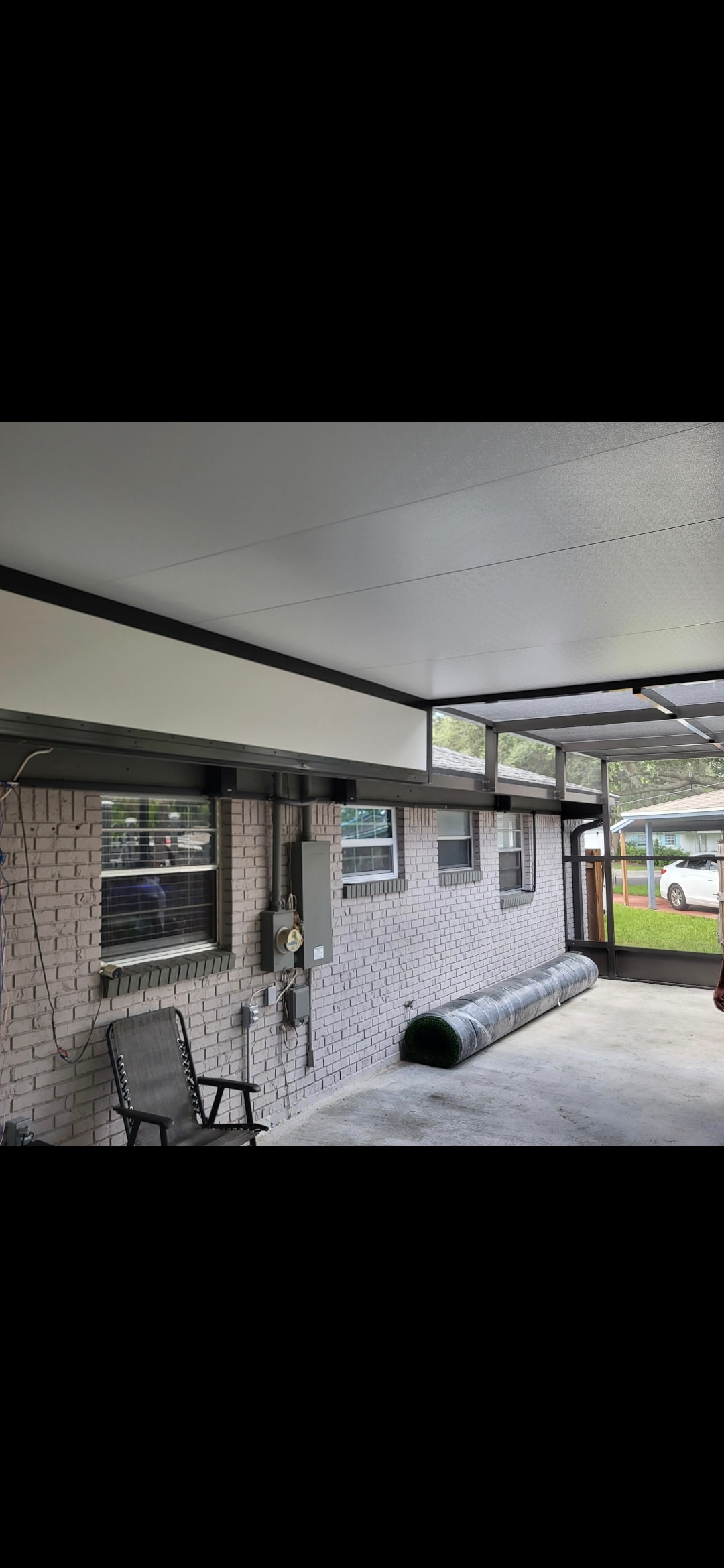 Patio cover installation on brick home with white ceiling panels