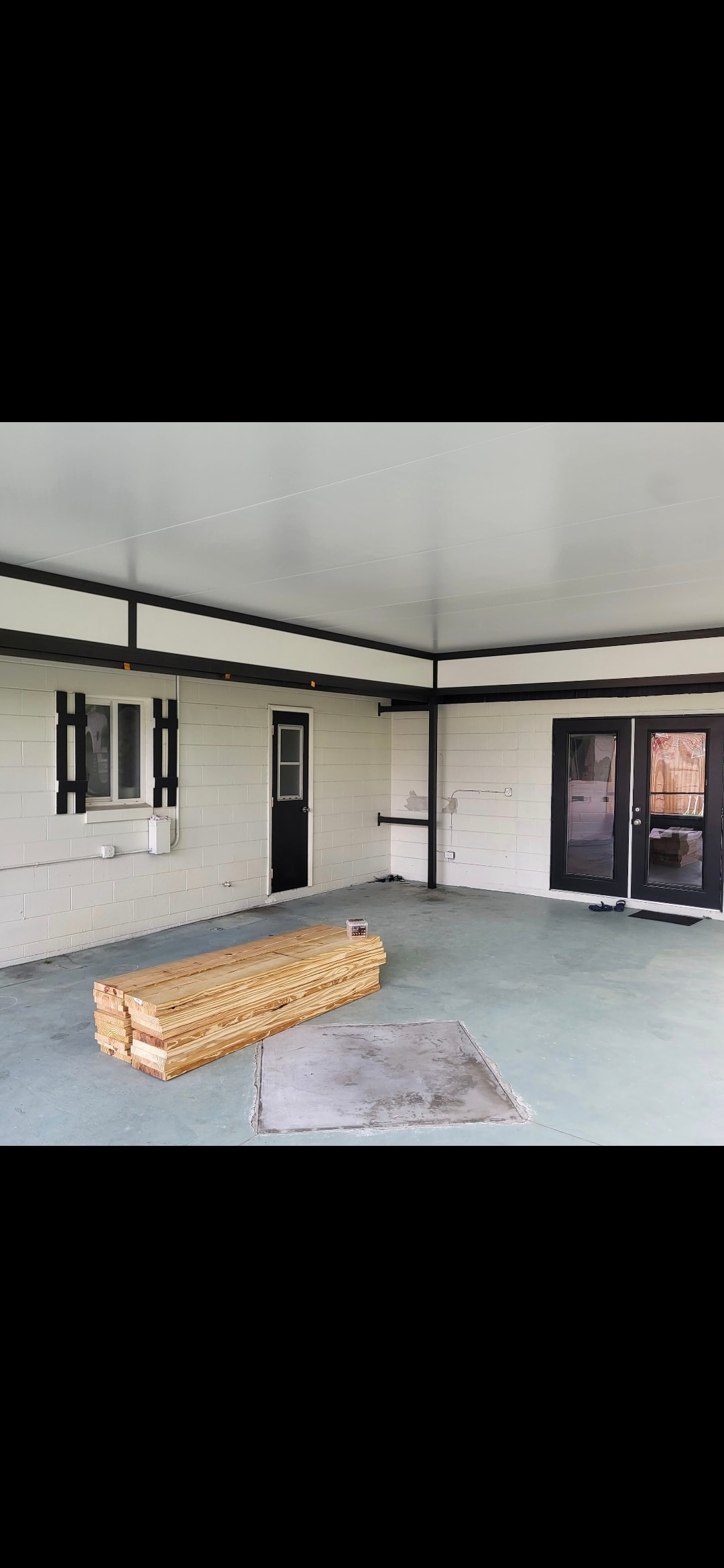 Interior view of finished screen room with white ceiling panels and black trim